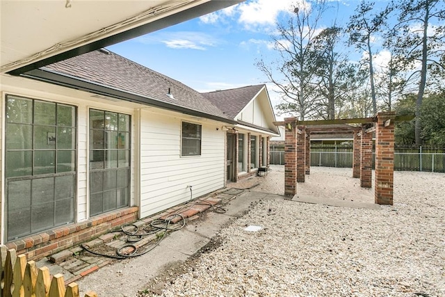 back of house featuring a patio area, a pergola, roof with shingles, and a fenced backyard