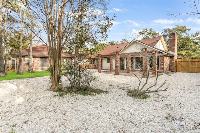 back of property featuring a chimney and fence