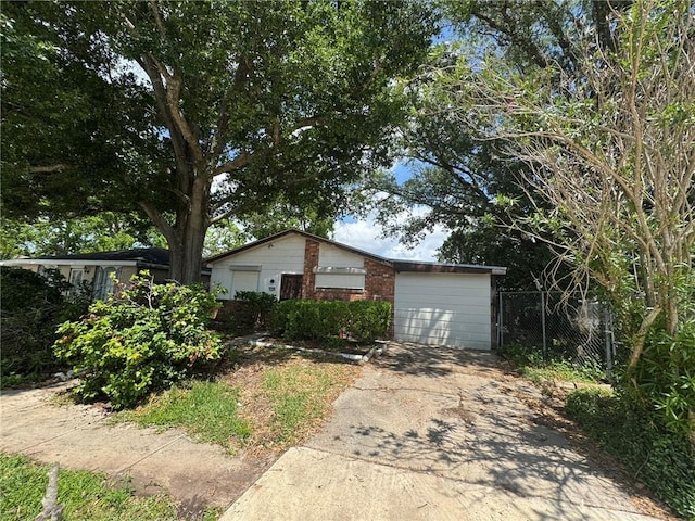 view of front of property featuring driveway, an attached garage, and fence