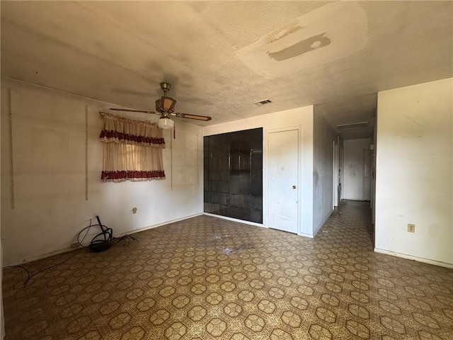 unfurnished bedroom featuring a ceiling fan, a closet, a textured ceiling, visible vents, and baseboards