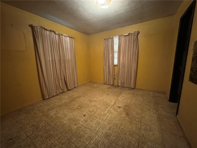 unfurnished room featuring a textured ceiling