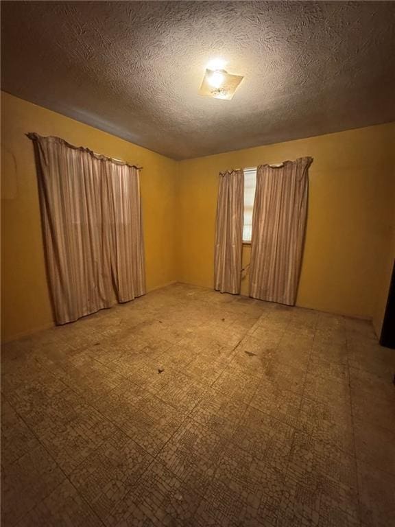 unfurnished room featuring a textured ceiling