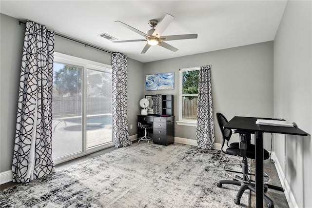 office area featuring baseboards, plenty of natural light, visible vents, and a ceiling fan