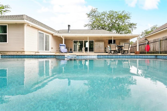 outdoor pool with a patio area and fence