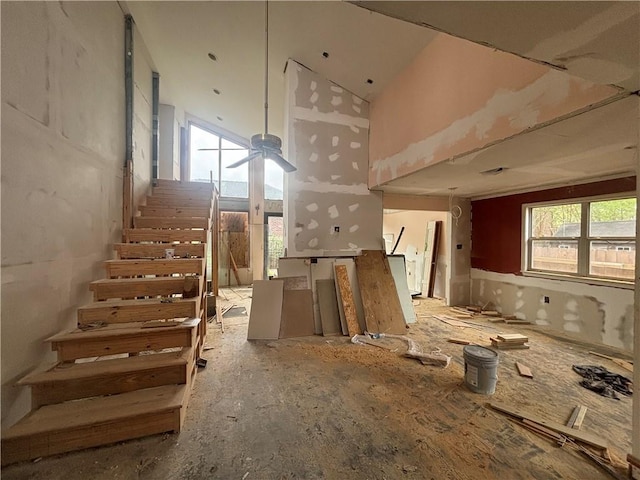 interior space featuring stairway, a ceiling fan, and high vaulted ceiling