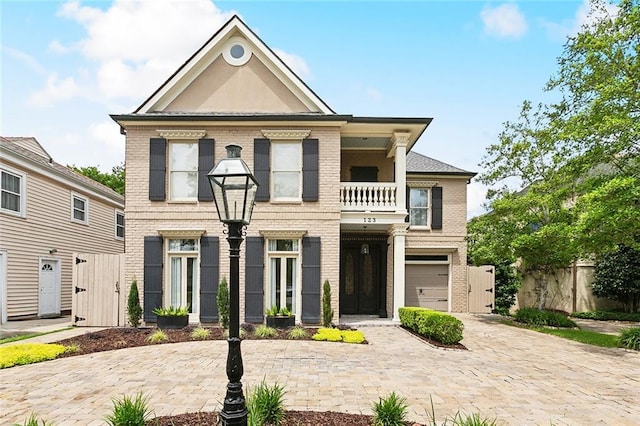 123 N Livingston Pl, Metairie, LA 70005 - view of front facade with a garage, fence, decorative driveway, a balcony, and brick siding