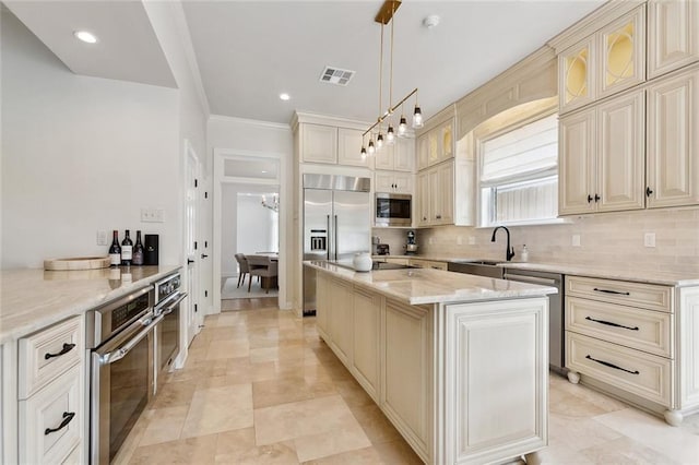 123 N Livingston Pl, Metairie, LA 70005 - kitchen featuring built in appliances, visible vents, a sink, backsplash, and cream cabinets