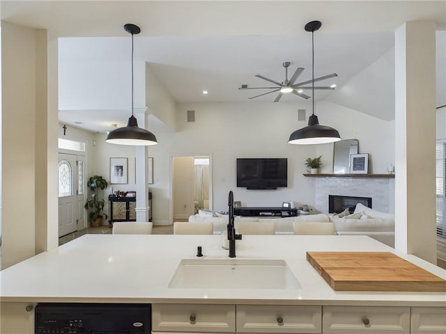 kitchen with light countertops, a fireplace, open floor plan, and ceiling fan