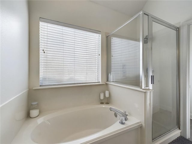 full bathroom featuring a stall shower, a garden tub, and plenty of natural light