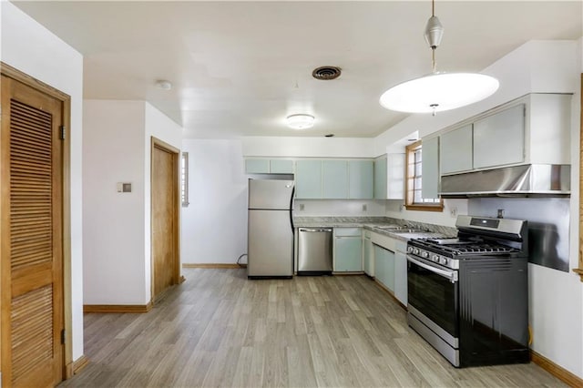 3025 Jefferson Ave, New Orleans, LA 70125 - kitchen featuring stainless steel appliances, under cabinet range hood, light wood-type flooring, a sink, and light countertops