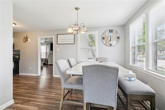 dining area featuring baseboards, dark wood-style flooring, a healthy amount of sunlight, and a chandelier