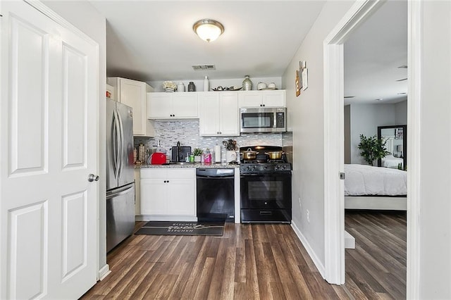 kitchen with tasteful backsplash, dark wood finished floors, visible vents, black appliances, and white cabinets