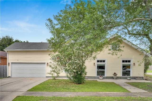 obstructed view of property with concrete driveway, a garage, and a front lawn