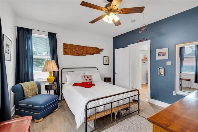 bedroom with light wood-type flooring, ceiling fan, and baseboards