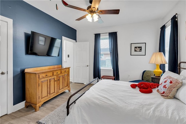 bedroom featuring light wood-style flooring, baseboards, and a ceiling fan
