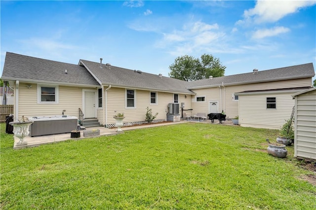 rear view of house featuring entry steps, a patio, a hot tub, a shingled roof, and central air condition unit
