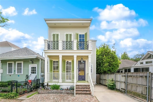 335 Joseph St, New Orleans, LA 70115 - view of front facade featuring covered porch, fence private yard, and a balcony