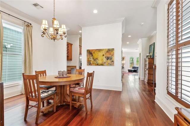 335 Joseph St, New Orleans, LA 70115 - dining space featuring visible vents, crown molding, an inviting chandelier, dark wood-style floors, and baseboards