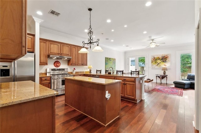 335 Joseph St, New Orleans, LA 70115 - kitchen featuring a peninsula, visible vents, under cabinet range hood, appliances with stainless steel finishes, and ornamental molding