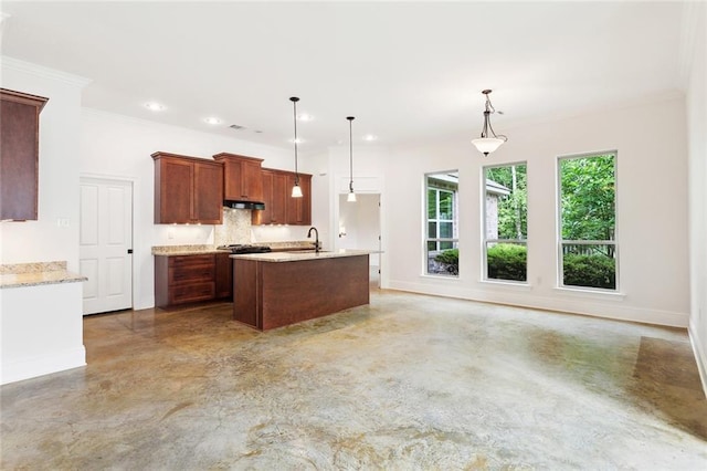 kitchen featuring hanging light fixtures, concrete floors, a sink, baseboards, and under cabinet range hood