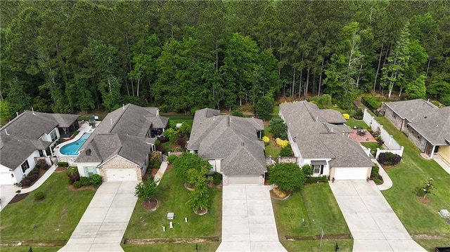 drone / aerial view featuring a residential view and a view of trees