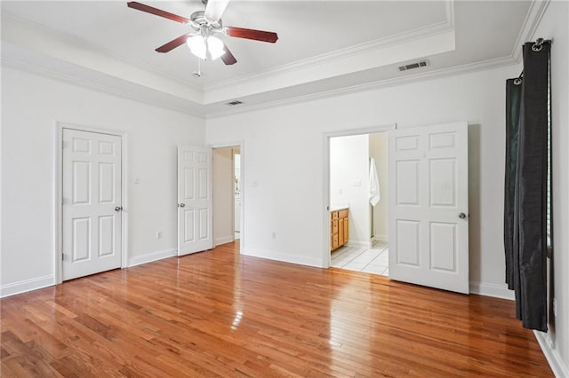 71238 Shady Lake Dr, Covington, LA 70433 - unfurnished bedroom with light wood-style floors, crown molding, a tray ceiling, and visible vents
