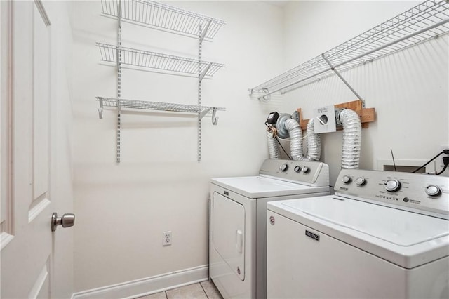 71238 Shady Lake Dr, Covington, LA 70433 - clothes washing area with washer and dryer, laundry area, light tile patterned floors, and baseboards