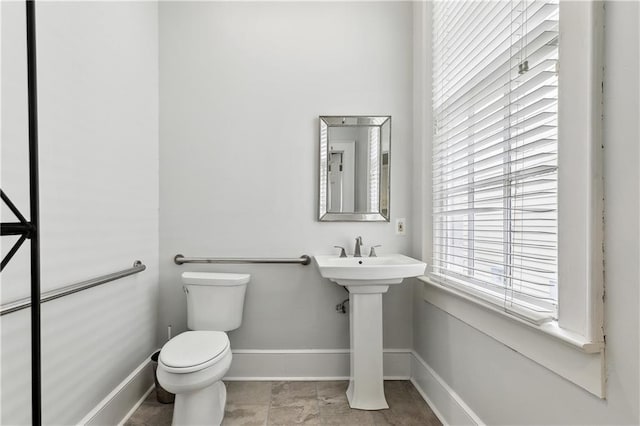 bathroom featuring toilet and baseboards