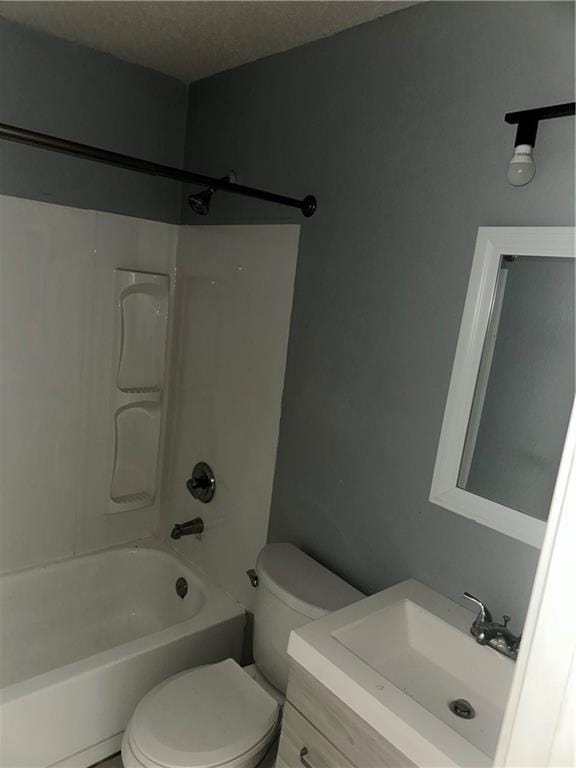 full bathroom with  shower combination, toilet, a textured ceiling, and vanity