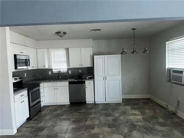 kitchen featuring stainless steel appliances, tasteful backsplash, visible vents, white cabinetry, and baseboards