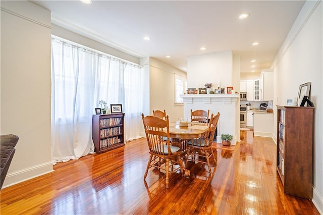 dining area featuring baseboards, recessed lighting, and wood finished floors