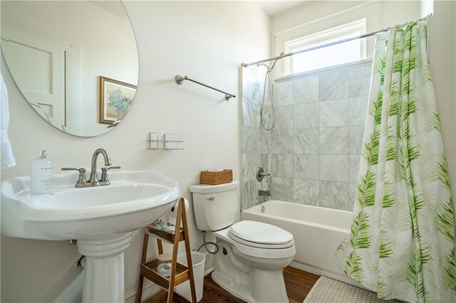 full bath featuring toilet, wood finished floors, and shower / bath combo
