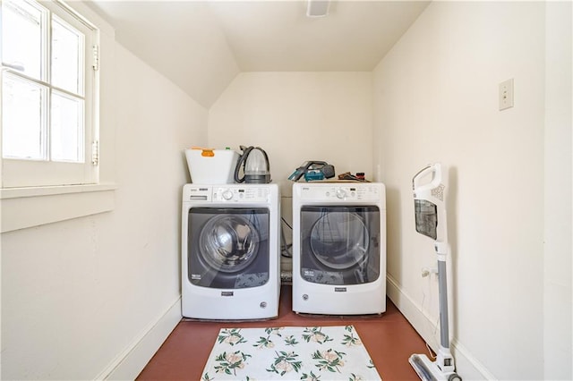 clothes washing area with washer and dryer, laundry area, and baseboards
