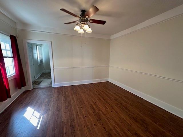 526 Bellecastle St, New Orleans, LA 70115 - unfurnished room featuring dark wood-type flooring, a ceiling fan, baseboards, and ornamental molding