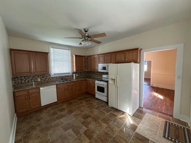 526 Bellecastle St, New Orleans, LA 70115 - kitchen featuring white appliances, a ceiling fan, backsplash, a sink, and dark stone finish floors
