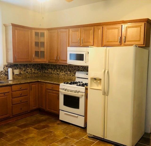 526 Bellecastle St, New Orleans, LA 70115 - kitchen featuring white appliances, decorative backsplash, glass insert cabinets, and brown cabinets