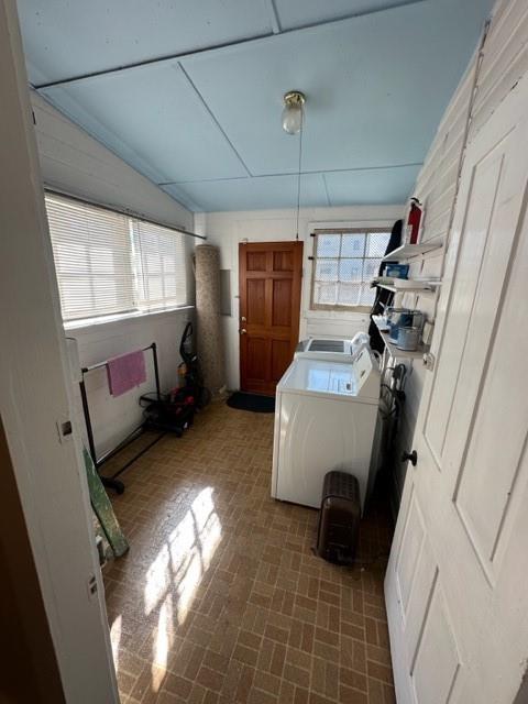 526 Bellecastle St, New Orleans, LA 70115 - laundry room with brick patterned flooring and washing machine and clothes dryer