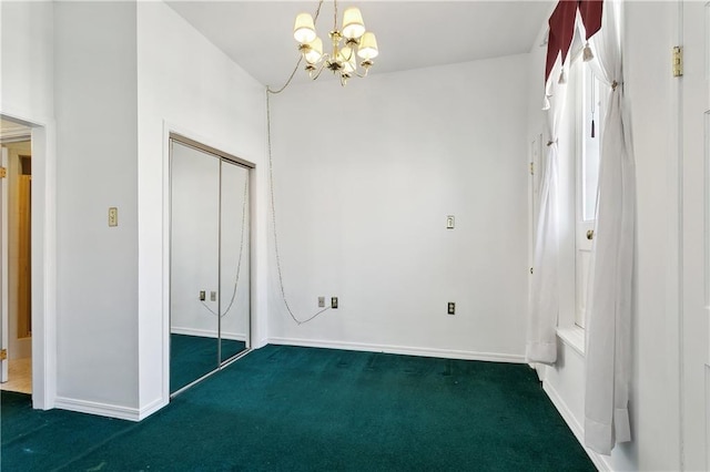interior space featuring dark colored carpet, baseboards, and a notable chandelier
