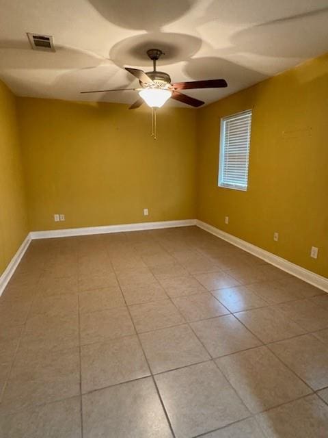 tiled spare room with baseboards, a ceiling fan, and visible vents