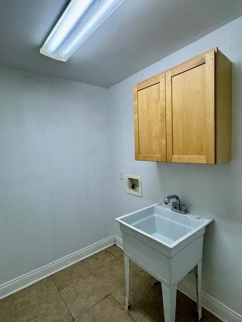 washroom with cabinet space, hookup for a washing machine, and baseboards