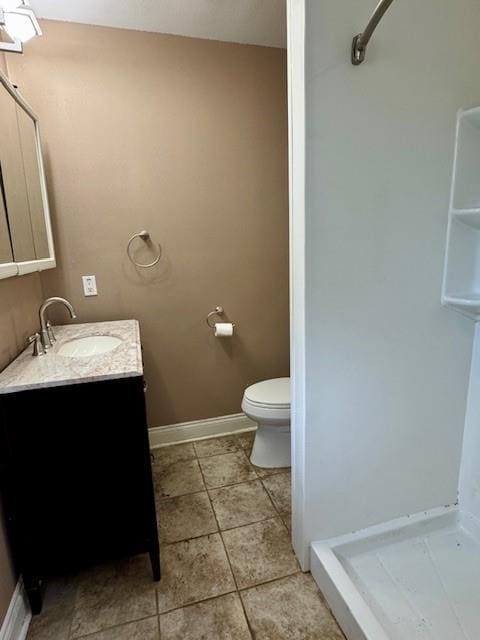 full bath featuring toilet, baseboards, tile patterned floors, vanity, and a shower