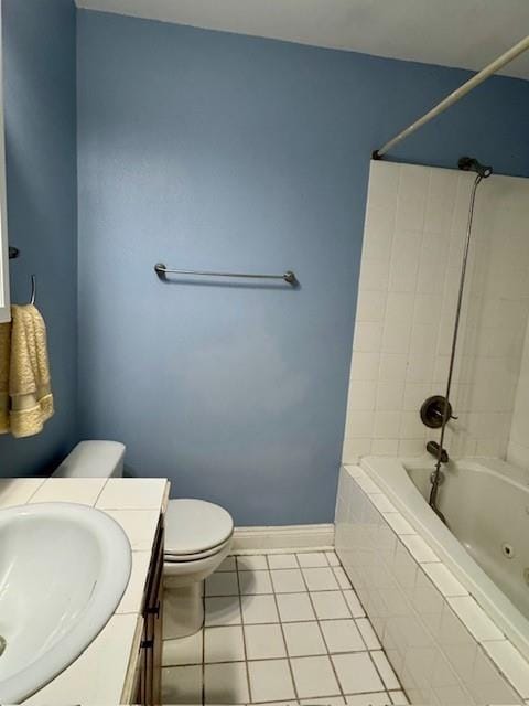 bathroom with tiled shower / bath combo, toilet, baseboards, tile patterned flooring, and vanity