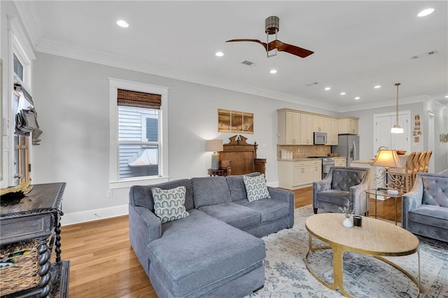 living room featuring crown molding, baseboards, ceiling fan, light wood-style floors, and recessed lighting