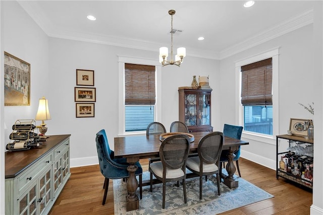 dining area with a chandelier, wood finished floors, baseboards, and visible vents