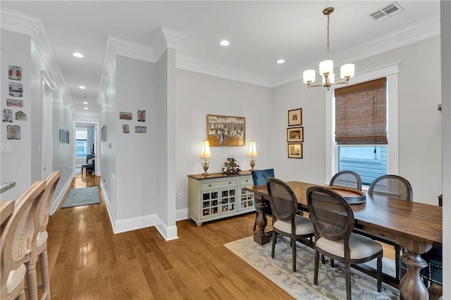 dining space with light wood finished floors, visible vents, baseboards, and a notable chandelier