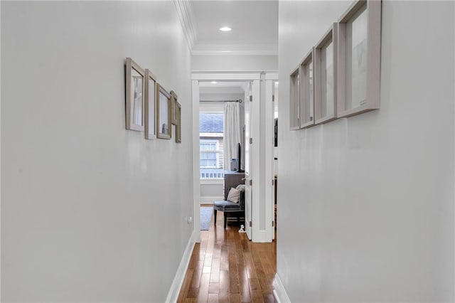corridor with hardwood / wood-style flooring, ornamental molding, baseboards, and recessed lighting