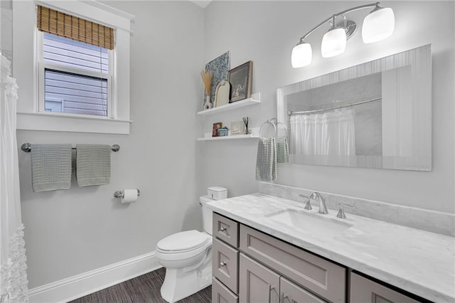 bathroom featuring toilet, wood finished floors, vanity, curtained shower, and baseboards