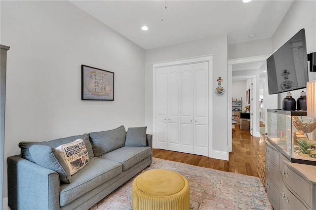 living room with wood finished floors, baseboards, and recessed lighting