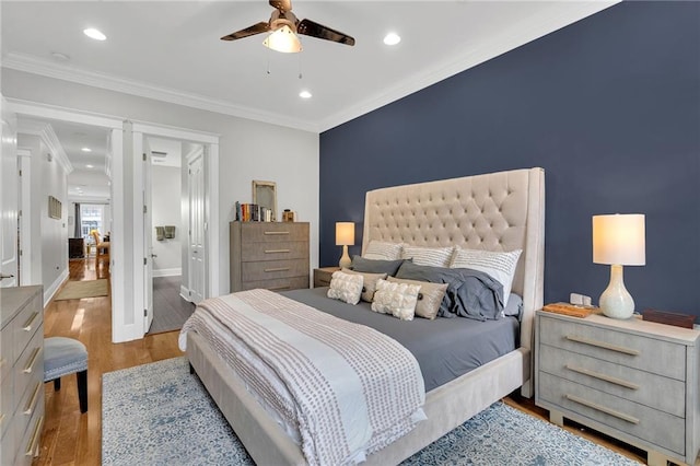bedroom with wood finished floors, decorative columns, crown molding, ensuite bathroom, and recessed lighting