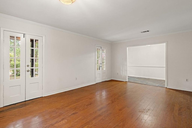 empty room with baseboards, wood-type flooring, visible vents, and plenty of natural light